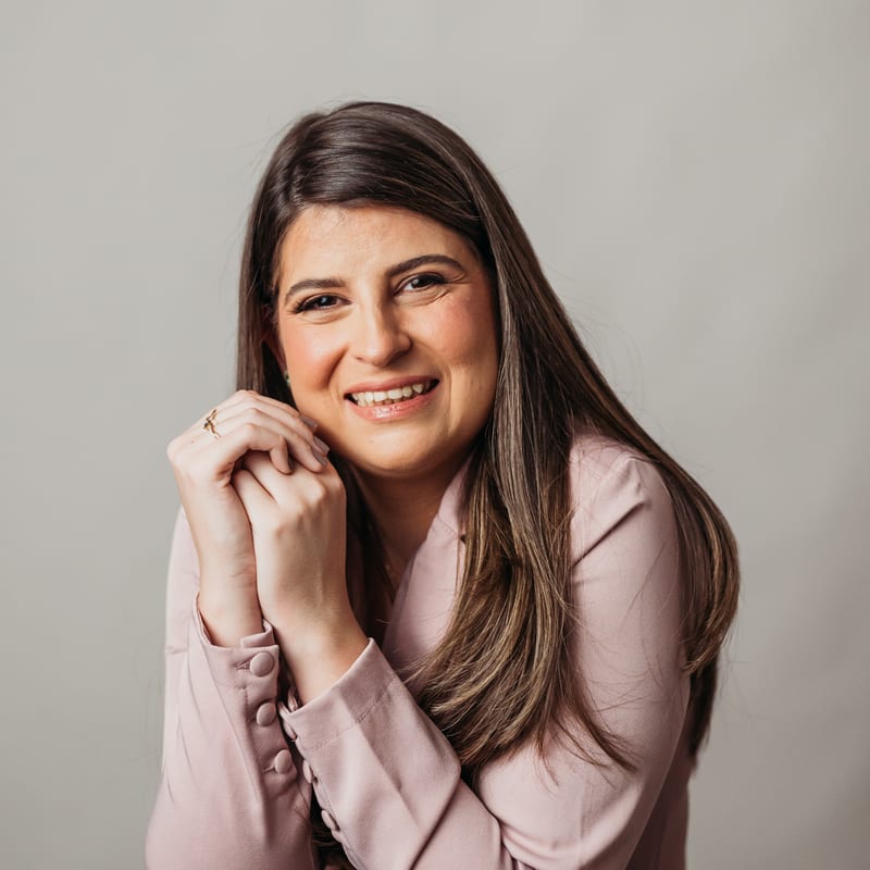 Dra. Marina Borges sorrindo de jaleco rosa